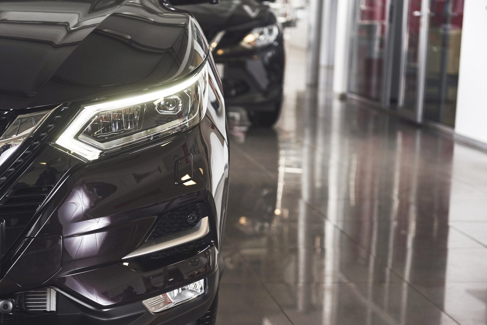 The headlights and the hood of a black luxury car The headlights and the hood of a black luxury car.